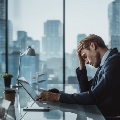 Imageofastressedbusinessmanathisdesk